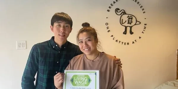 Deon and Jennifer holding a Certified Living Wage Employer certificate at Sarang Kitchen
